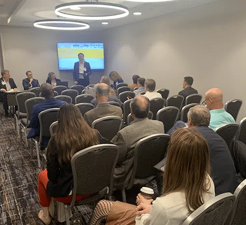A panel discussion at the Animal AgTech Innovation Summit, with a speaker presenting to a seated audience.