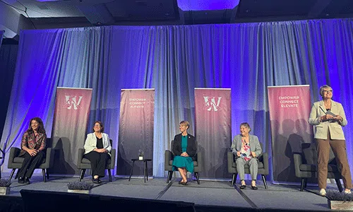 Sally Day of Kincannon & Reed moderating a panel of speakers on stage at the Women in Agribusiness 2025 Summit.